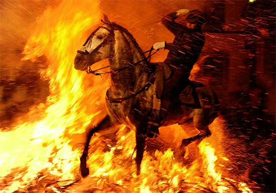 A man rides a horse through a bonfire on January 16, 2012 in the small village of San Bartolome de Pinares, Spain - Jasper Juinen/Getty Images